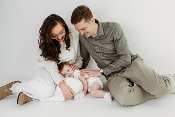 Natural mother, father and daughter portrait captured before a first birthday cake smash.