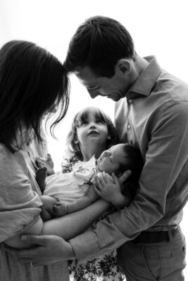 Black and white family portrait of parents and two children.
