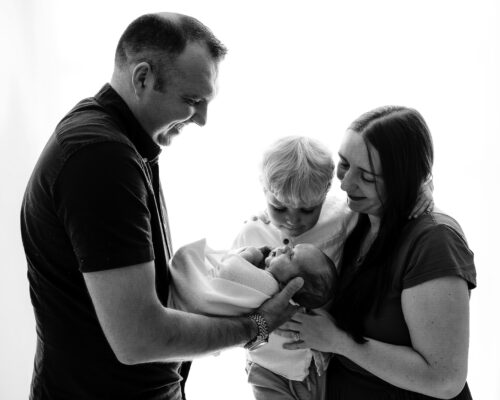 Black and white family portrait with parents and two children.