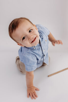 Baby Boy smiling at camera before First Birthday Cake Smash Photography
