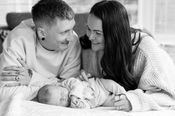 Parents cuddling their children during a relaxed family photoshoot.